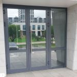 Алюминиевые входные двери серого цвета с тонировкой для бизнес-центра