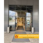 Входная группа бизнес-центра с автоматическими раздвижными дверями серого цвета