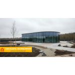 Здание сложной архитектуры с фасадным остеклением панорамными окнами в пол