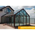Зимний сад частного дома с панорамным остеклением профилем коричневого цвета
