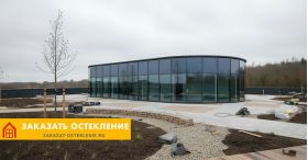 Здание сложной архитектуры с фасадным остеклением панорамными окнами в пол