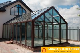 Зимний сад частного дома с панорамным остеклением профилем коричневого цвета