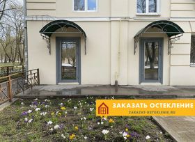 Теплая алюминиевая дверь серого цвета со стеклопакетом на входе в дом