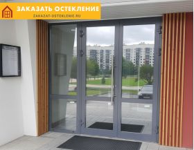 Распашная входная группа серого цвета с панорамным остеклением для офисного здания