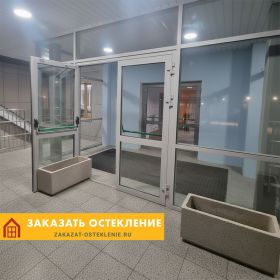 Алюминиевая входная группа в офисное здание с белой распашной дверью