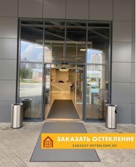 Входная группа бизнес-центра с автоматическими раздвижными дверями серого цвета