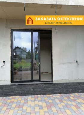 Дом с остеклением алюминиевым порталом черного цвета